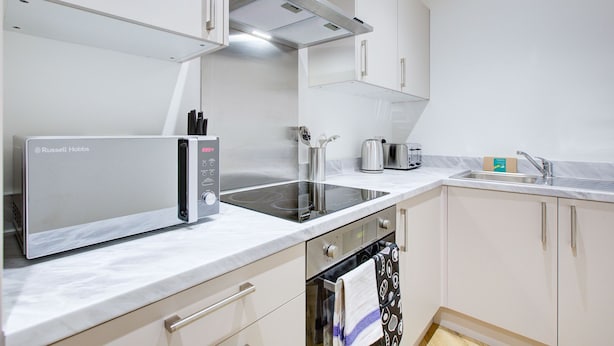 Une cuisine moderne équipée d’un four encastré, d’un four à micro-ondes et d’une plaque de cuisson.