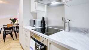 Una cuina moderna amb fogó integrat, microones i campana extractora d'acer inoxidable.