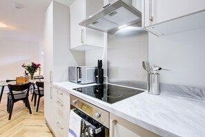 Uma cozinha moderna com fogão embutido, micro-ondas e exaustor de aço inoxidável.
