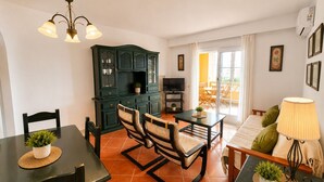 A living room with a dining area, a TV, and a sofa. - Alcaraván T2, Sea view apartment - Ref. 11P21 (Ayamonte)