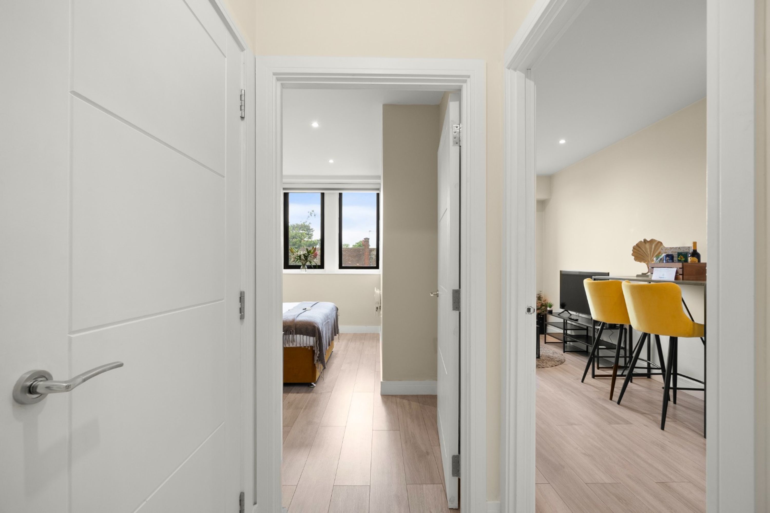 A modern interior with a dining area, a bed, and a view of the outdoors.