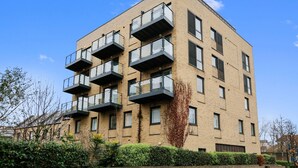 Ein mehrgeschossiges Wohngebäude mit Balkonen und einer Ziegel Fassade.