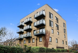 A multi-story residential building with balconies and a brick facade. - Hybrid Resi - Greenwich - Two-Bedroom Apartment (London)