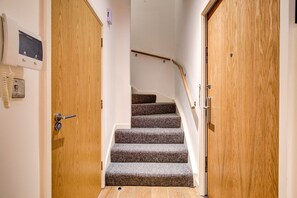 Eine Holztreppe mit Teppichstufen, die zu einer Empore führen.