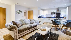 Un salon moderne comprenant un canapé, une table basse et un coin repas avec des chaises et une table.