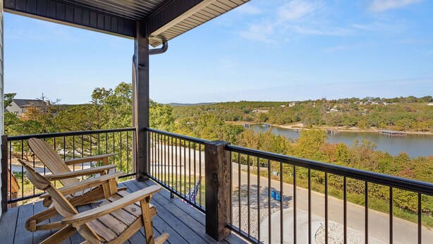 A covered outdoor area with a view of a lake and surrounding landscape. - Lux Lake View: Sleeps 12+, Hot Tub, Game Room, Theater, Fire Pit (Branson)