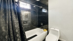 A modern bathroom with a bathtub, toilet, and a shower area. - Wonderful two story, 2-bedroom apartment with AC in vibrant Detroit (Detroit)