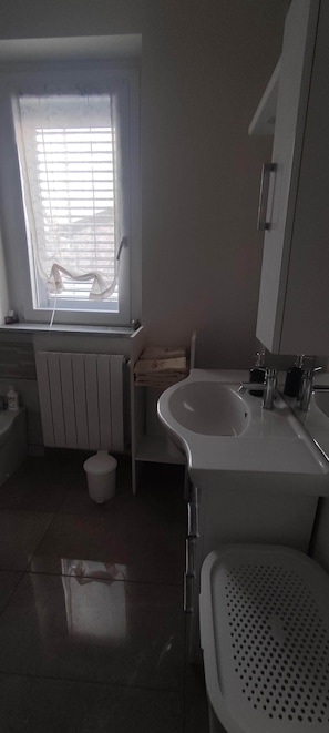 Ein Badezimmer mit Fenster, Toilette, Waschbecken und Bidet.