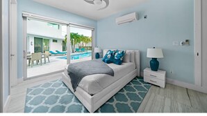 A modern bedroom with a bed, a nightstand, a lamp, and a ceiling fan. - Luxury Pool Villa Steps From Stunning Beach Beautiful Views EAST TOWER ONLY (Moss Town)