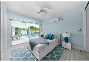 A modern bedroom with a bed, a nightstand, a lamp, and a ceiling fan. - Luxury Pool Villa Steps From Stunning Beach Beautiful Views EAST TOWER ONLY (Moss Town)