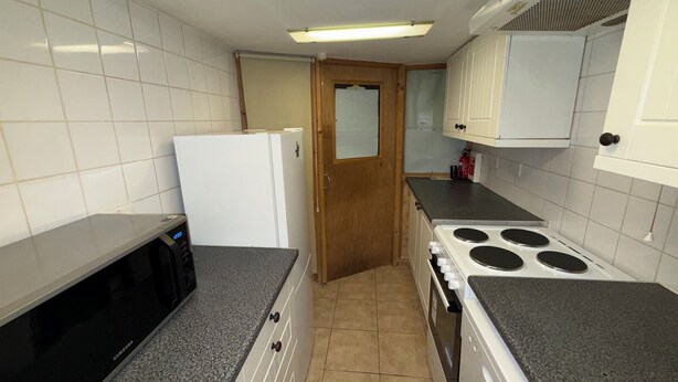 A kitchen with white cabinets, a microwave, a refrigerator, a stove, and a tiled floor. - Charming flat for short-term rent on a quiet,well-kept street close to Hyde Park (London)