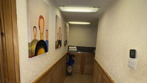 A hallway with patterned walls, a wooden floor, and artwork on the walls. - Charming flat for short-term rent on a quiet,well-kept street close to Hyde Park (London)