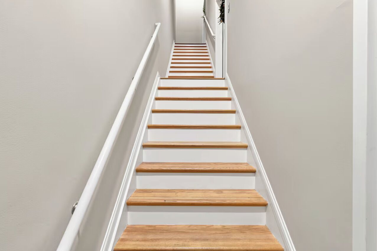 A staircase with white walls and wooden steps.
