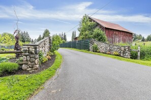 A rural road leading to a red barn with a stone wall and a metal gate. - Peaceful 1-bedroom apartment with private entry in charming Snohomish (Snohomish)