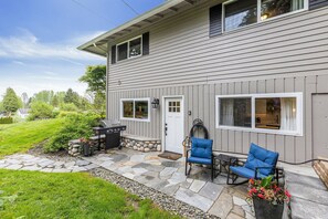 A house with a stone patio, outdoor furniture, and a barbecue grill. - Peaceful 1-bedroom apartment with private entry in charming Snohomish (Snohomish)