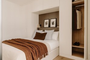 Une chambre à coucher avec un lit, une armoire et une étagère contenant des livres et des photos.