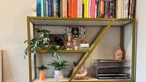 A bookshelf with books, decorative items, and a small figurine. - Beautiful 1-bedroom apartment in Hollywood with AC, pool, gym, Hollywood sign (West Hollywood)