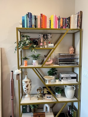 Ein Bücherregal mit Büchern, Dekoration und einer kleinen Figur.