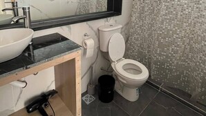 A bathroom with a marble vanity, a sink, a toilet, and a shower curtain. - Modern house with views just steps from Lake Nahuel Huapi (Dina Huapi)