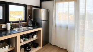 A modern kitchen with a built-in refrigerator, a sink, and a window with sheer curtains. - Modern house with views just steps from Lake Nahuel Huapi (Dina Huapi)