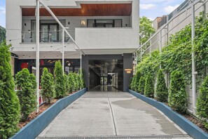 A modern building with a central entrance, surrounded by greenery and a clear pathway. - Crown Penthouse  Luxurious Spa Vista (București)