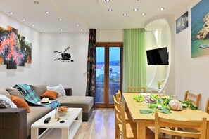 Una sala moderna con sofá, mesa de centro y comedor listo para una comida.