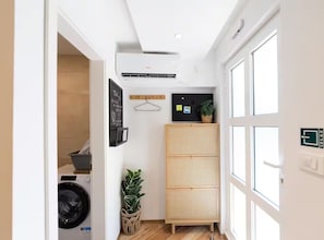 A laundry area with a washing machine, a drying rack, and a wall-mounted air conditioner. - Marghareta Apartment NO 1 - TOP Location - Studio Apartment (Dubrovnik)