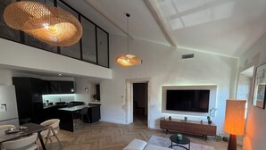 Een moderne woonruimte met een bank, eettafel en keukenhoek.