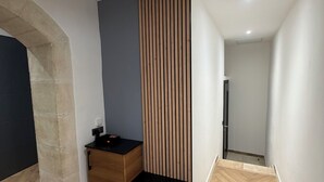 Een modern interieur met een houten kast, een verticale houten paneel en een visgraatvloer.