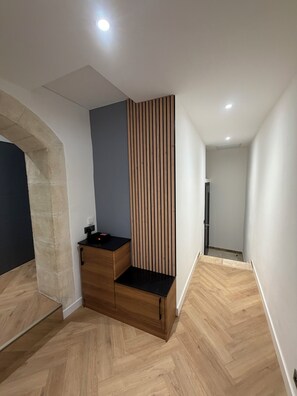 Ein modernes Interieur mit einem Holzkabinett, einer vertikalen Holzpaneeleinlage und einem Fischgrätparkett.