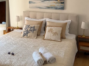 A neatly made bed with a quilted cover, two starfish pillows, and rolled towels. - Tina Sea View Retreat (Vodice)