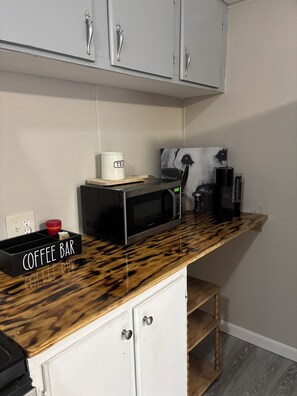 Eine Küche mit einer Kaffeobar, einer Mikrowelle und einer Kaffeemaschine.