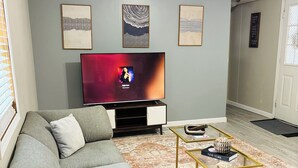 Una sala de estar con un sofá, una mesa de centro y un televisor.