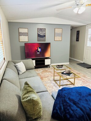 Ein Wohnzimmer mit einer Couch, einem Couchtisch und einem Fernseher.