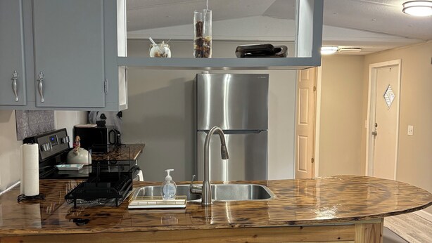 Una cocina moderna con una isla central, electrodomésticos de acero inoxidable y piso de madera.