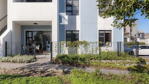 A residential building with a modern design, featuring a flat facade, large windows, and a visible laundry area. - Neo-African apartment at the entrance of Durbanville wine route (Cape Town)