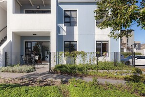 A residential building with a modern design, featuring a flat facade, large windows, and a visible laundry area. - Neo-African apartment at the entrance of Durbanville wine route (Cape Town)