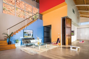 Ein großzügiger Wohnbereich mit Treppe, einem Glastisch und einem modernen Sofa.