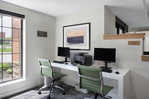 A modern office with two desks, computers, and chairs.