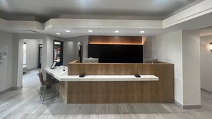 Ett välkomstområde med en bardisk i trä, infällda taklampor och en modern design.