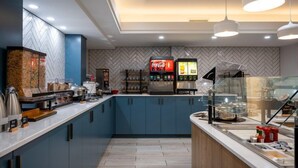 A modern kitchen with a herringbone-patterned backsplash, a Coca-Cola refrigerator, and a glass display case. - Suite w/ Fireplace & Full Kitchen | Free Breakfast (West Des Moines)