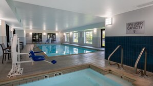 An indoor swimming pool with clear water, a lifeguard chair, and a sign indicating spa user capacity. - Accessible Studio Suite w/ Tub | Free Breakfast! (West Des Moines)