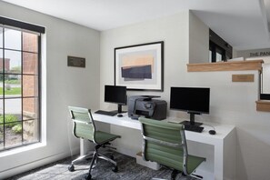 A modern office with two desks, computers, and chairs.
