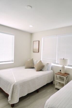 A bedroom with a bed, two bedside tables, a lamp, and a picture on the wall. - Stylish Central San Diego Home - Close to Everything (San Diego)