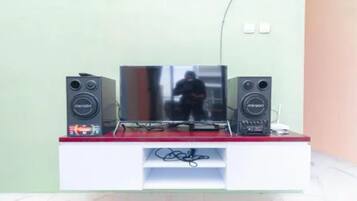 A television on a white stand with two speakers on either side.