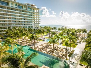 Ein Hotel mit einem großen Pool, Palmen und Blick auf den Ozean.