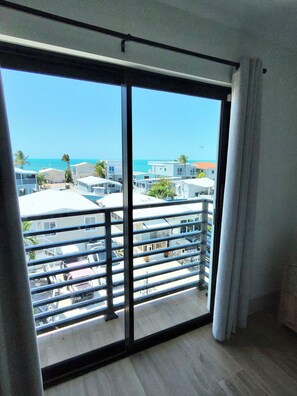 Ein Balkon mit Blick auf das Meer und Gebäude.