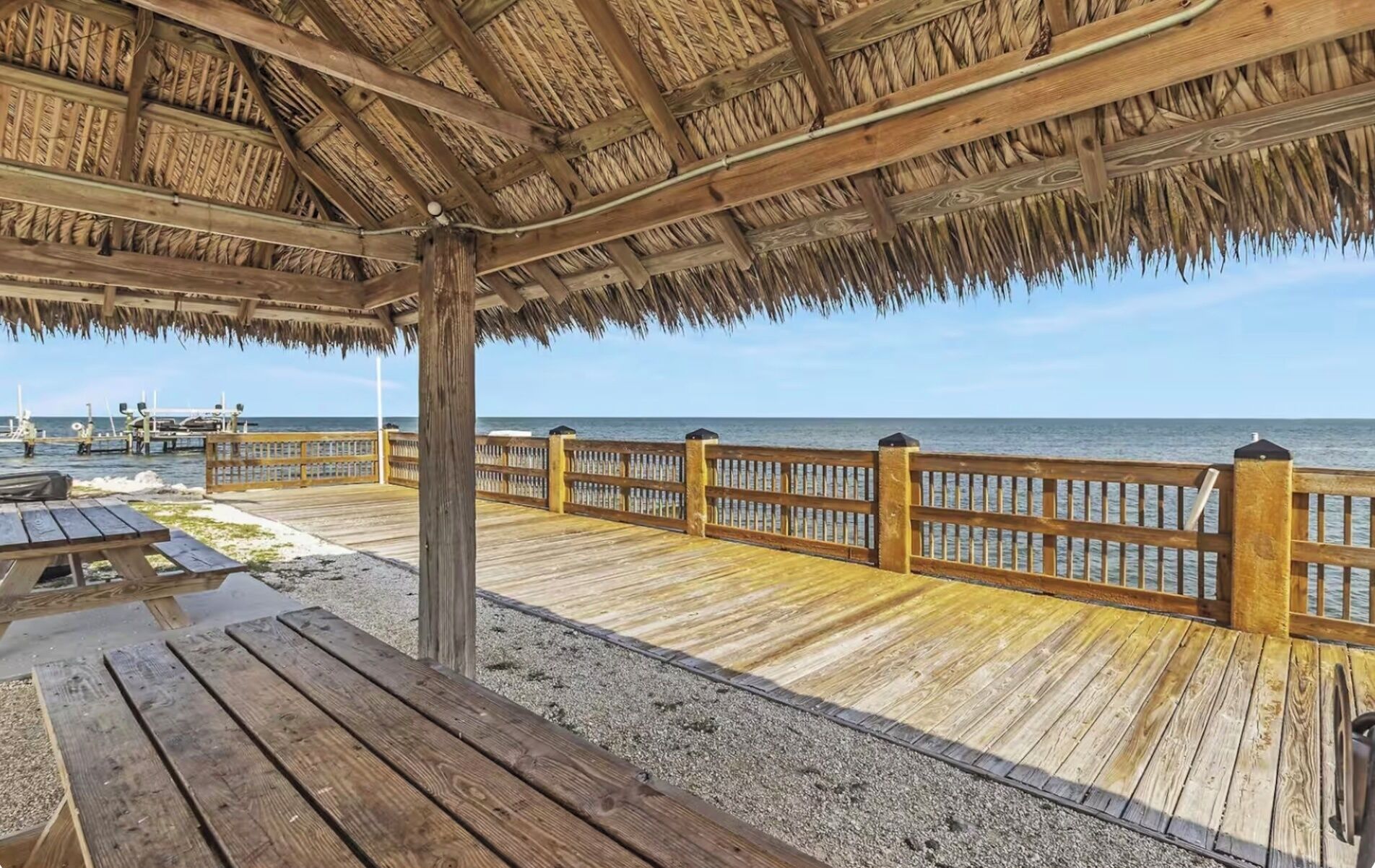 Ein mit Reeds gedecktes Holzdeck mit Blick auf das Meer.