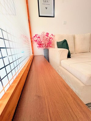 A room with a wooden bench, a beige sofa, a pink flower vase, and a framed quote on the wall. - Cozy one bedroom apartment (Ongata Rongai)