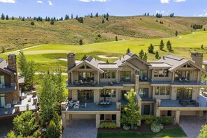 A multi-story house with a patio, a fire pit, and a view of a golf course. - Abode at White Clouds, hot tub, Sun Valley (Sun Valley)